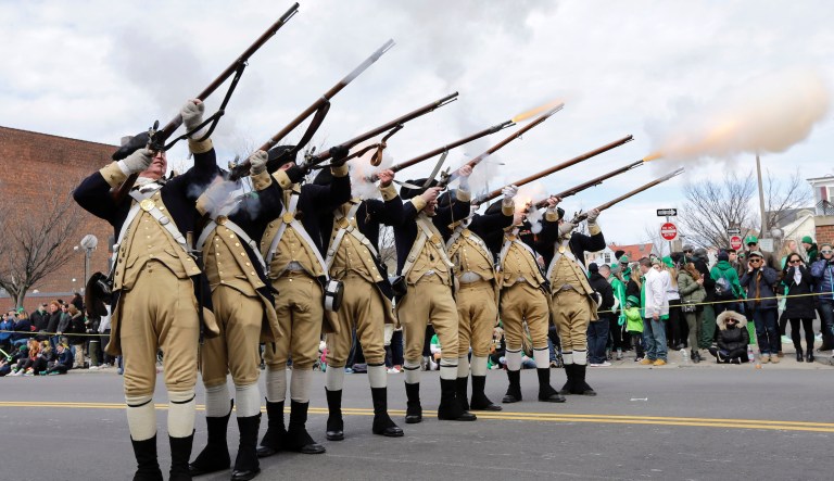 Members of the Lexington Minute Men Company fire their muskets during the annual St. Patrick's Day Parade, Sunday, March 20, 2016, in Boston.
