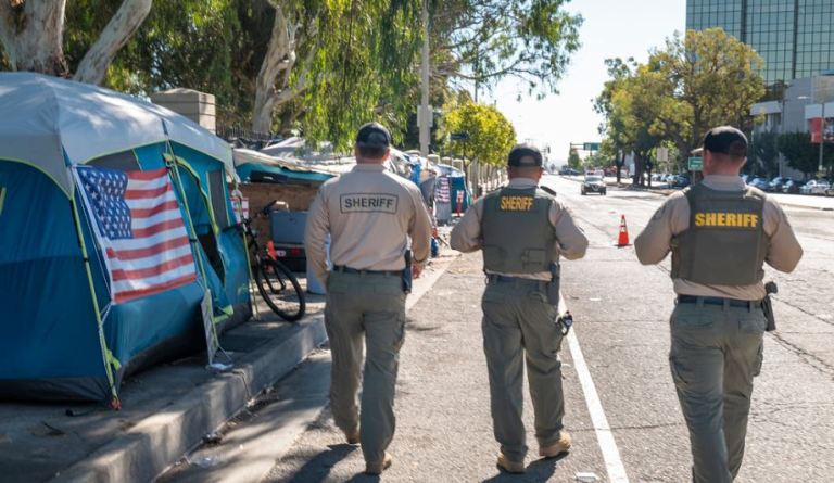 Los Angeles County sheriff's deputies assist the homeless along Veterans Row with new housing.