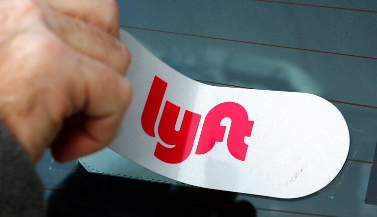 In this  Jan. 31, 2018, file photo, a Lyft logo is installed on a Lyft driver's car in Pittsburgh. Lyft is cutting 13% of its workforce.