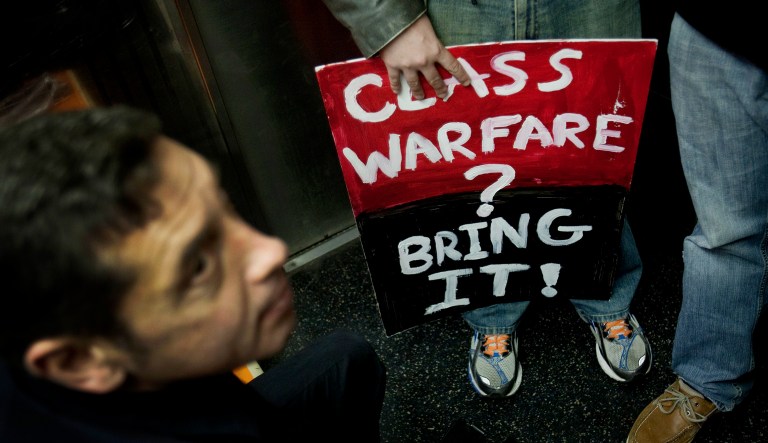 A sign held by a protester says "Class Warfare? Bring It!" in New York.