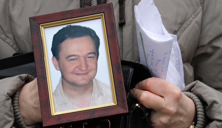 In this Monday, Nov. 30, 2009, file photo a portrait of lawyer Sergei Magnitsky who died in jail, is held by his mother Nataliya Magnitskaya, as she speaks during an interview with the AP in Moscow.