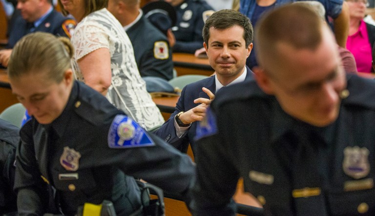 Democratic Presidential candidate and South Bend, Indiana Mayor Pete Buttigieg sits behind officers following a swearing-in ceremony on Wednesday, June 19, 2019, during a Board of Public Safety meeting inside the South Bend Police Department in South Bend, Ind.
