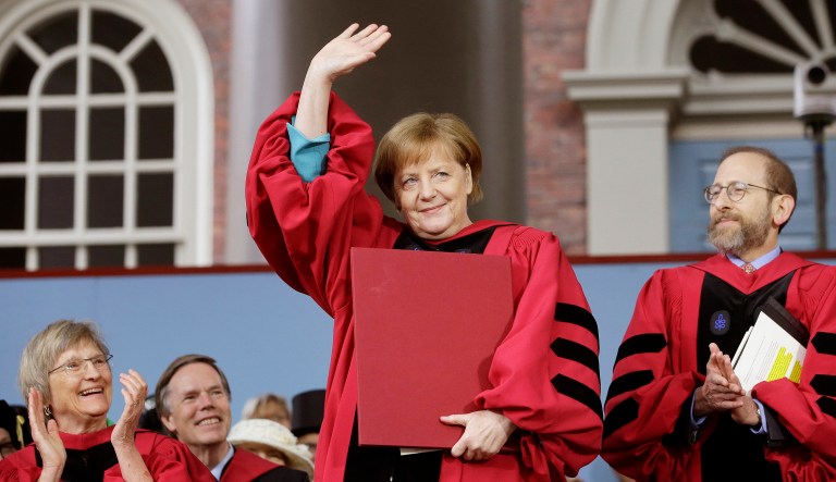 German Chancellor Angela Merkel, center, waves as she is presented with an honorary Doctor of Laws degree.