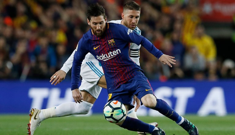 Barcelona's Lionel Messi, front, steers the ball past Real Madrid's Sergio Ramos during a Spanish La Liga soccer match between Barcelona and Real Madrid, dubbed 'el clasico', at the Camp Nou stadium in Barcelona, Spain, Sunday, May 6, 2018.