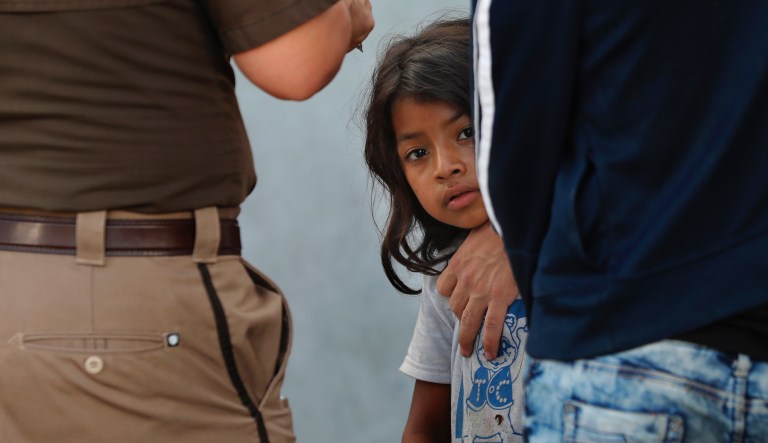 A child and her father wait to board a bus that will take them and other migrants to Monterrey, from an immigration center in Nuevo Laredo, Mexico, Thursday, July 18, 2019.