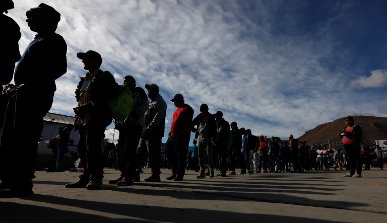 Migrants line up for donated food inside a former concert venue serving as a shelter for migrants in Tijuana, Mexico, Sunday, Dec. 2, 2018. 