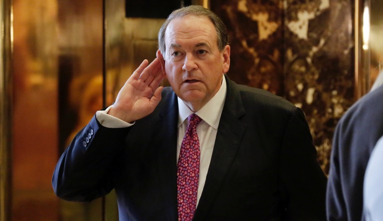 Former Arkansas Gov. Mike Huckabee cups his ear to hear a reporter's question as he waits for the elevator at Trump Tower in New York, Friday, Nov. 18, 2016.