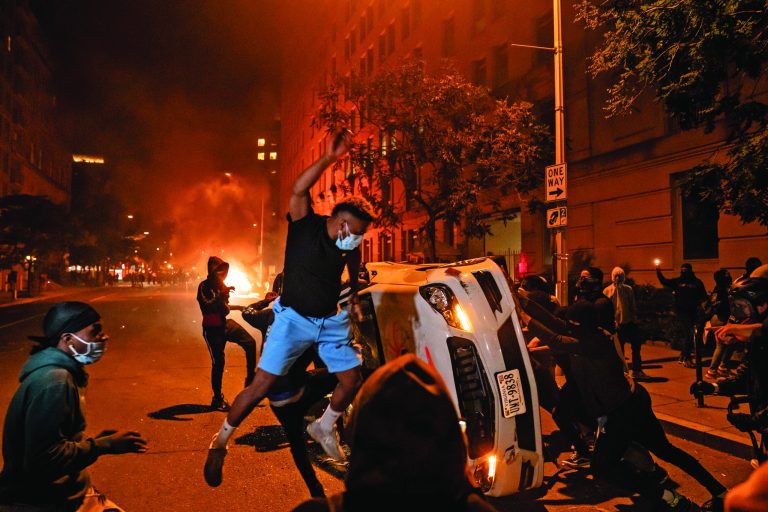 Demonstrators vandalize a car as they protest the death of George Floyd, May 31, 2020, near the White House in Washington, D.C. 