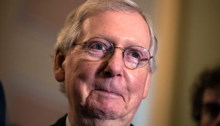 Senate Majority Leader Mitch McConnell, R-Ky., smiles as he meets with reporters as work continues on a plan to keep the government as a funding deadline approaches, at the Capitol in Washington, Tuesday, Feb. 6, 2018. 