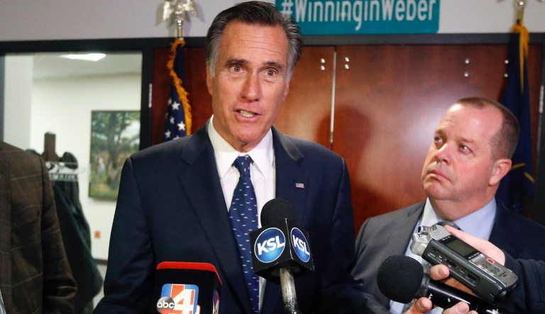 In this Friday Jan., 18, 2019 photo, Utah Sen. Mitt Romney, left, speaks with reporters in Ogden, Utah.