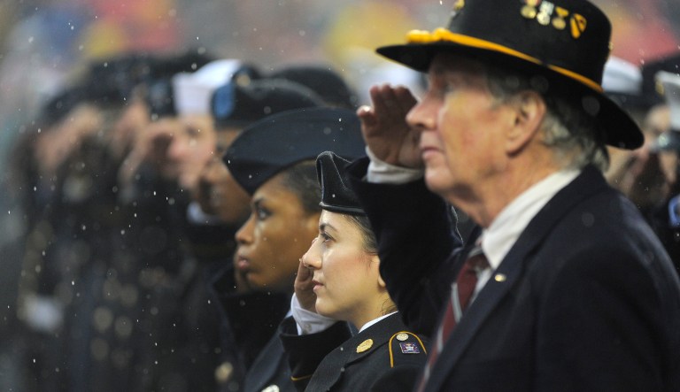Military personnel salute during a salute to service military appreciation month before an NFL football game between the Kansas City Chiefs and the San Diego Chargers in Kansas City, Mo.