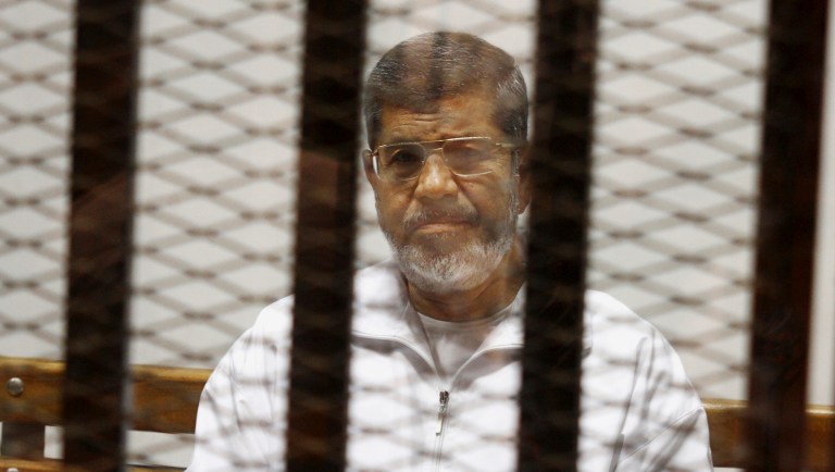 FILE - In this May 8, 2014 file photo, Egypt's ousted Islamist President Mohammed Morsi sits in a defendant cage in the Police Academy courthouse in Cairo, Egypt. An Egyptian court sentenced ousted President Mohammed Morsi to death, Saturday, May 16, 2015,  over  a 2011 mass prison break.. 