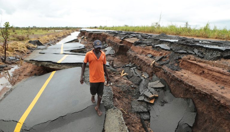 A man passes through a section of the road damaged  by Cyclone Idai in Nhamatanda about 50 kilometers from Beira, Mozambique, Friday March, 22, 2019.