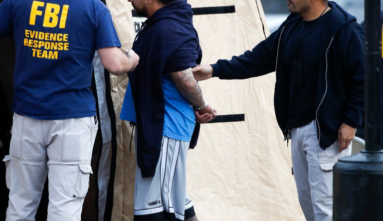 A man is taken into custody by FBI agents Wednesday, May 17, 2017, in Los Angeles. Hundreds of federal and local law enforcement fanned out across Los Angeles, serving arrest and search warrants as part of a three-year investigation into the violent and brutal street gang MS-13.