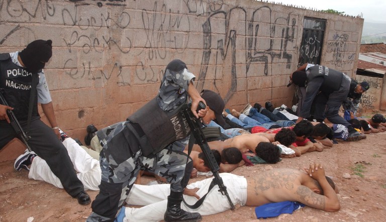 Police officers detain members of the Mara 18 and MS 13 gangs. 