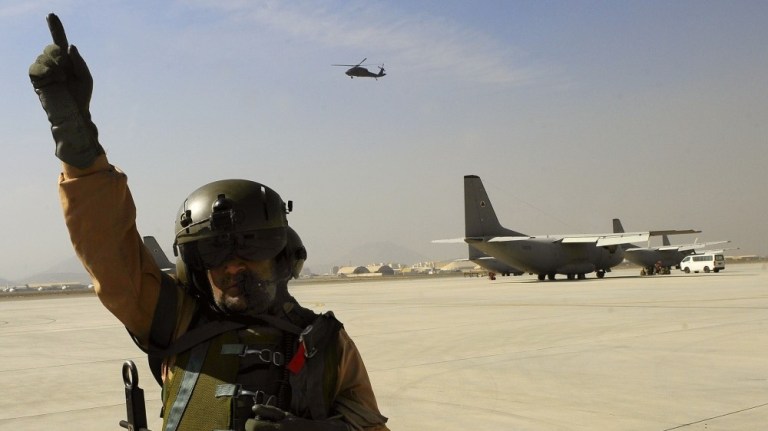 Afghan air force crew chief Sgt. Lull Mohammad tells the pilot to start engines while on fire guard before a training flight, Oct. 23, 2012 at Kabul International Airport as part of the NATO Training Mission in Afghanistan.