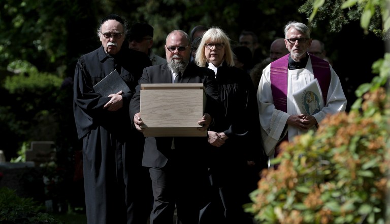 A cemetery staff member holds a box with the remains of political prisoners of the Nazi regime in Berlin, Germany, Monday, May 13, 2019.