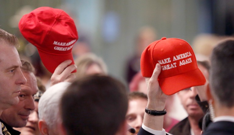 Members in the audience hold up "MAKE AMERICA GREAT AGAIN" hats at the conclusion of a speech by Vice President Mike Pence at an event on March 22, 2018, in Manchester, N.H.