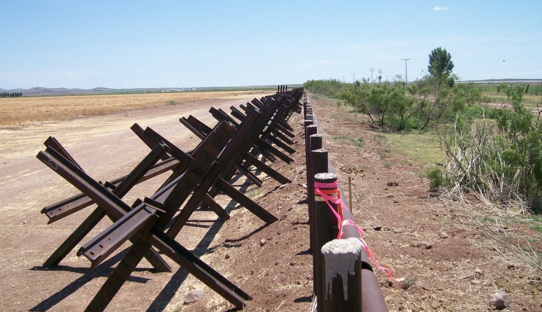 FILE - In this June 29, 2007 file photo, a portion of the U.S.- Mexico border near Columbus, New Mexico, shows the disputed metal pipe fence on the right that protrudes into Mexico by several feet. On the left is a temporary border made of steel railroad track. President Donald Trump is not giving up on his demands for $5.7 billion to build a wall along the U.S.-Mexico border, saying a physical barrier is central to any strategy for addressing the security and humanitarian crisis at the southern border. Democrats argue that funding the construction of a steel barrier along roughly 234 miles will not solve the problems.