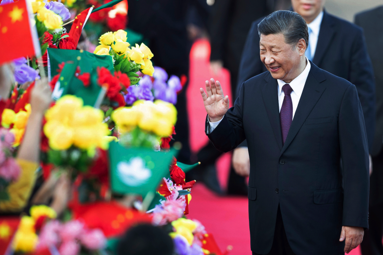 Chinese President Xi Jinping greets children holding Chinese and Macau flags after arriving at Macao Airport, December 18, 2019, as Xi will attend the 20th anniversary of Macau's return to China. (AP Photo)