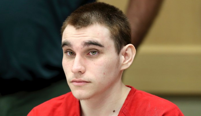 In this Dec. 10, 2019 Nikolas Cruz appears at a hearing in Fort Lauderdale Fla. The death penalty trial of Cruz, the man charged with killing 17 people at a Florida high school is off indefinitely because of restrictions related to the coronavirus.