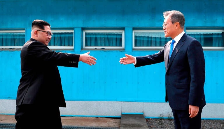 North Korean leader Kim Jong Un, left, prepares to shake hands with South Korean President Moon Jae-in over the military demarcation line at the border village of Panmunjom in Demilitarized Zone Friday, April 27, 2018. Their discussions will be expected to focus on whether the North can be persuaded to give up its nuclear bombs.