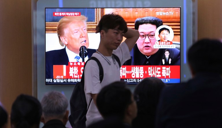 People watch a TV screen showing file footage of U.S. President Donald Trump, left, and North Korean leader Kim Jong Un during a news program at the Seoul Railway Station in Seoul, South Korea, Thursday, May 24, 2018. North Korea carried out what it said is the demolition of its nuclear test site Thursday, setting off a series of explosions over several hours in the presence of foreign journalists.The signs read: " North Korea demolishes nuclear test site ."