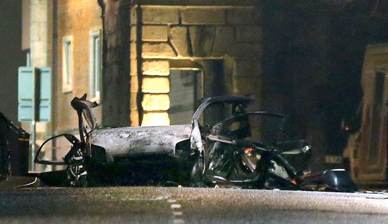This photo taken on Saturday, Jan. 19, 2019 shows the scene of a suspected car bomb on Bishop Street in Londonderry, Northern Ireland. Northern Ireland politicians are condemning a car bombing outside a courthouse in the city of Londonderry. The device exploded Saturday night as police, who had received a warning, were evacuating the area. The Police Service of Northern Ireland posted a photograph of a vehicle in flames and urged the public to stay away.