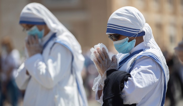 Nuns wearing gloves and masks to prevent the spread of COVID-19 pray in St. Peter's Square at the Vatican, Sunday, May 31, 2020. Pope Francis has cheerfully greeted people in St. Peterâs Square on Sunday, as he resumed his practice of speaking to the faithful there for the first time since lockdown began in Italy and at the Vatican in early March. Instead of the tens of thousands of people who might have turned out on a similarly brilliantly sunny day like this Sunday, in pre-pandemic times, perhaps a few hundred came to the square, standing well apart from others or in small family groups. 