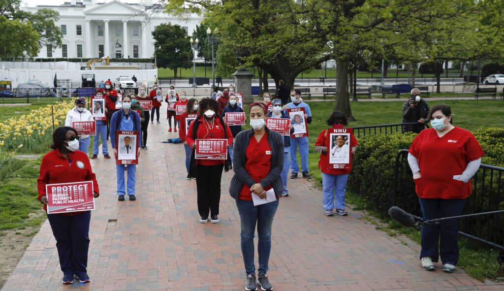Nurses from National Nurses United practice social distancing as they protest in front of the White House, Tuesday, April 21, 2020, in Washington. The group sought to bring attention to health care workers across the country who have contracted COVID-19 due to a lack of personal protective equipment.