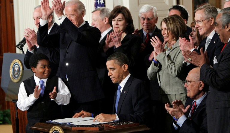 FILE - In this March 23, 2010, file photo President Barack Obama is applauded after signing the Affordable Care Act into law in the East Room of the White House in Washington. Government cost estimates for expanding Medicaid to millions more low-income people are increasing faster than expected, raising questions about a vital part of President Barack Obamaâs health care law. Estimated per-person costs were an eye-catching 49 percent higher than previously calculated, according to a recent report to Congress from nonpartisan experts with the federal Centers for Medicare and Medicaid Services. The new estimate of $6,366 per person for 2015 was nearly $2,100 higher than expected.