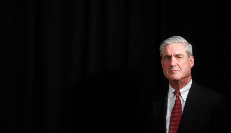 Then-FBI Director Robert Mueller listens as then-President Barack Obama speaks to staff members of the Joint Terrorism Task Force Headquarters in New York on Oct. 20, 2009.