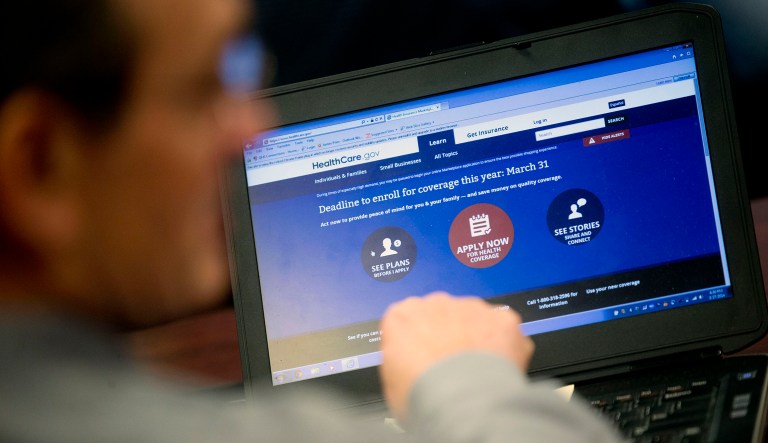 Marketplace guide Jim Prim works on the Healthcare.gov federal enrollment website as he helps a resident sign up for a health insurance plan under the Affordable Care Act at an enrollment event in Milford, Delaware, U.S., on Thursday, March 27, 2014.