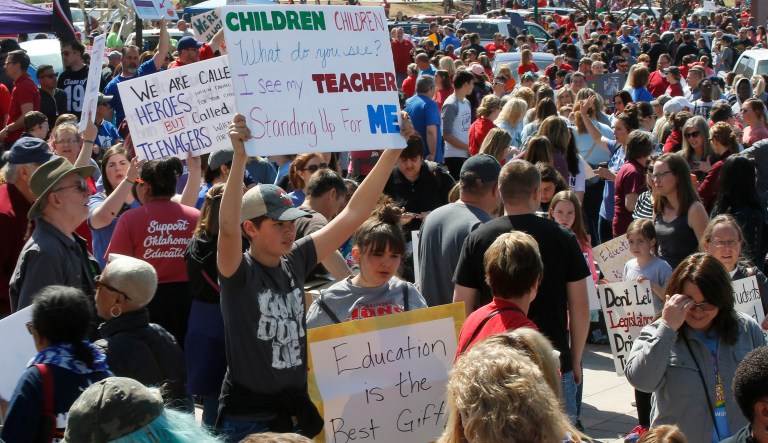 Students hold signs on the south plaza of the state Capitol as protests continue over school funding, in Oklahoma City, Monday, April 9, 2018.
