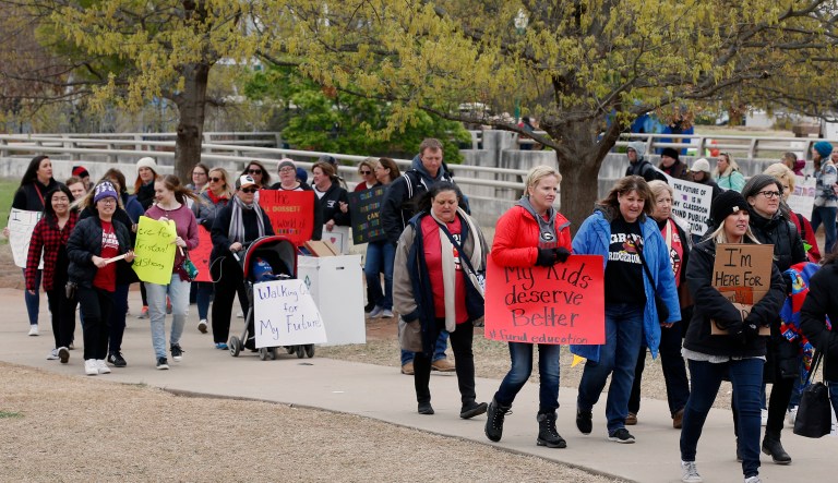 Supporters carry signs as they picket around the state Capitol during a teacher's rally in Oklahoma City, Monday, April 2, 2018. Teachers were holding separate protests in Oklahoma and Kentucky on Monday to voice dissatisfaction with issues like pay and pensions.