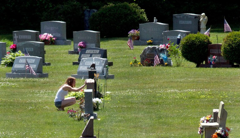 FILE - In this June 17, 2016 file photo, Erika Marble visits the gravesite of Edward Martin III, her fiancÃ© and father of her two children, in Littleton, N.H. The 28-year old died Nov. 30, 2014, from an overdose of the opioid Fentanyl. Drug overdose deaths increased by 33 percent in the past five years across the U.S. as of 2016. New Hampshire saw a 191 percent increase while Massachusetts, North Dakota, Connecticut and Maine saw death rates jump by more than 100 percent.