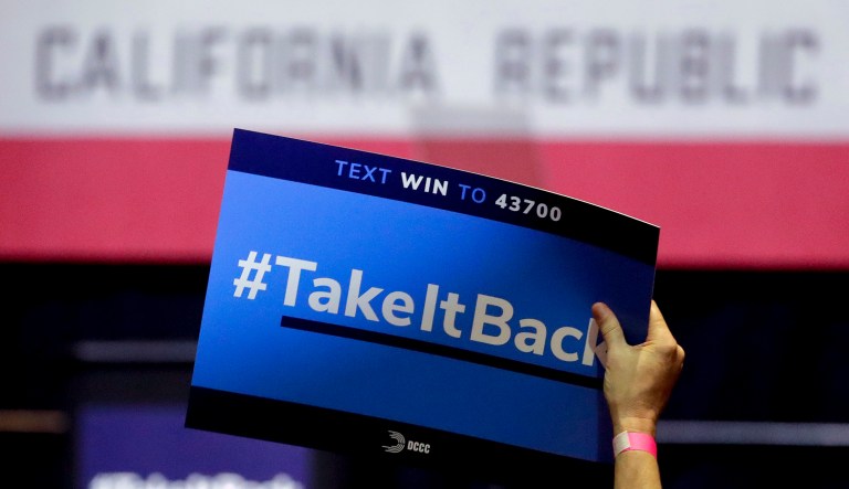 In this Thursday, Oct. 4, 2018, photo a supporter holds up a sign for Gil Cisneros, a candidate who is running for a U.S. House seat in the 39th District in California, at a rally on the Cal State Fullerton campus in Fullerton, Calif. For decades, Orange County, California, was known as a Republican stronghold but times have changed. A sign of the change is in the 39th District, where, Young Kim, a Korean immigrant Republican is running against Cisneros, a Hispanic Democrat.