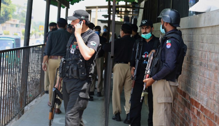 Police officers gather at an entry gate of district court following the killing of Tahir Ahmad Naseem, who was in court accused of insulting Islam, in Peshawar, Pakistan, Wednesday, July 29, 2020. 