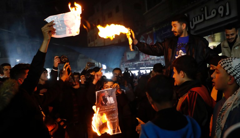 Protesters burn pictures showing U.S. President Donald Trump during a protest against the U.S. Mideast peace plan, at the main road market in Jebaliya refugee camp, Gaza Strip, Tuesday, Jan. 28, 2020. U.S. President Donald Trump is set to unveil his administration's much-anticipated Mideast peace plan in the latest U.S. venture to resolve the Israeli-Palestinian conflict.