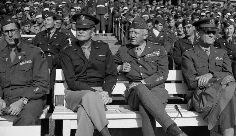 Gen. Dwight D. Eisenhower of the Army, second from left, and Gen. George S. Patton, second from right, are interested spectators at a football game in Victory Park, Frankfurt, Germany, Oct. 14, 1945, on the occasion of Eisenhower's 55th birthday.  Others are unidentified. 