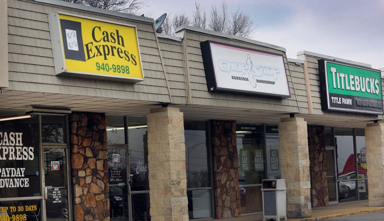 A barber shop stands between two short-term loan stores in Birmingham, Alabama, U.S., on Tuesday, Feb. 10, 2015.