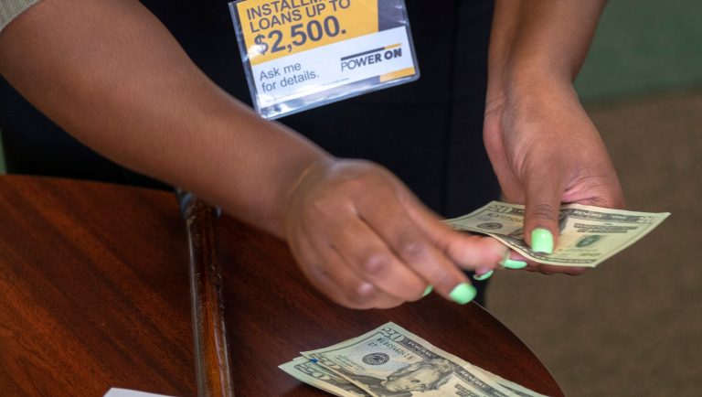 FILE- In this Aug. 9, 2018, photo a manager of a financial services store in Ballwin, Mo., counts cash being paid to a client as part of a loan. The nation's federal financial watchdog has announced its plans to roll back most of its consumer protections governing the payday lending industry. It's the Consumer Financial Protection Bureau's first rollback of regulations under its new Director, Kathy Kraninger, who took over the bureau late last year. 