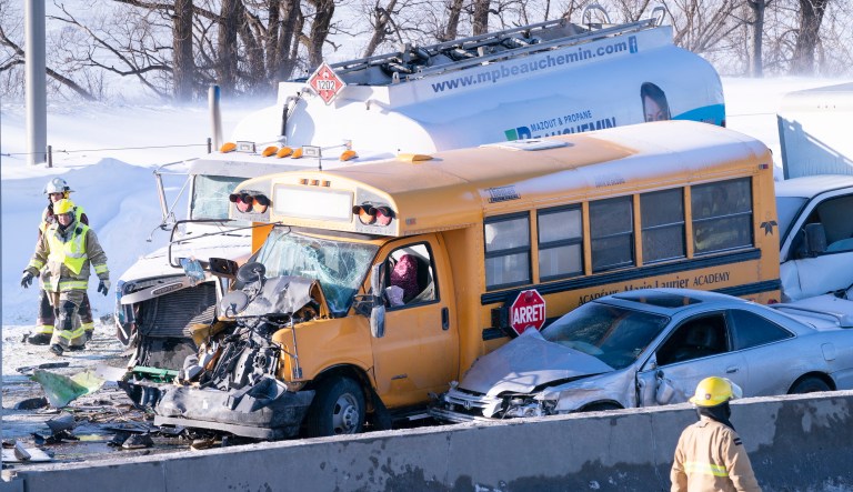 Emergency personnel gather at the scene following a multi-vehicle crash on the south shore of Montreal in La Prairie, Quebec, Wednesday, Feb. 19, 2020.