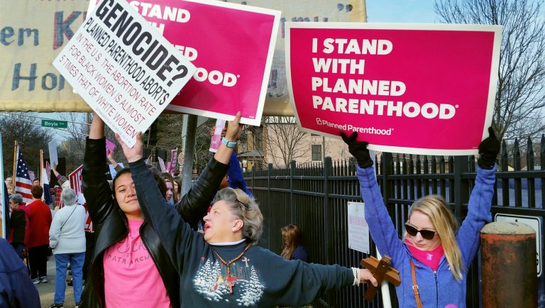 FILE - In this Feb. 11, 2017, file photo, a Planned Parenthood supporter and opponent try to block each other's signs during a protest and counter-protest of abortion in St. Louis. If a Supreme Court majority shaped by President Donald Trump overturns or weakens the right to abortion, the fight over its legalization could return to the states. 