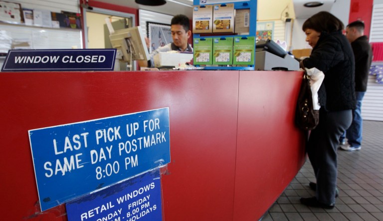 A customer gets stamps at a U.S. Post Office in San Jose, Calif., on Dec. 5, 2011.