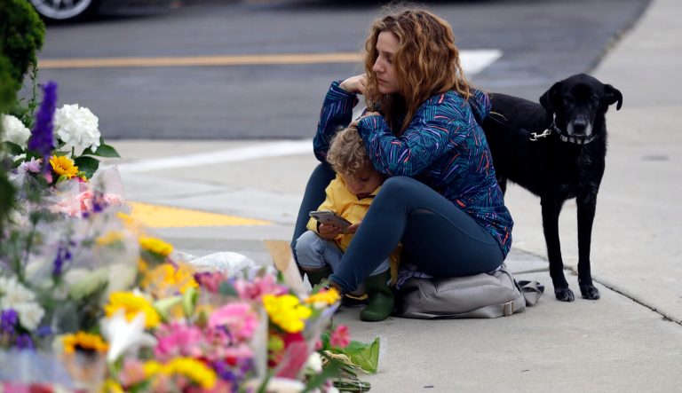 Ali De Leon pauses at a growing memorial with her son Leo and her dog Vinny across the street from the Chabad of Poway synagogue in Poway, Calif., on Monday, April 29, 2019. A gunman opened fire on Saturday, April 27 at the synagogue as dozens of people were worshipping exactly six months after a mass shooting in a Pittsburgh synagogue. 