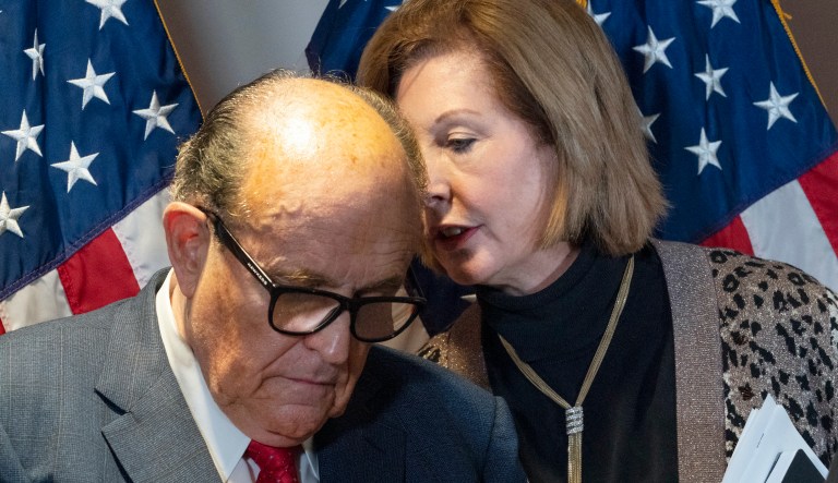Former Mayor of New York Rudy Giuliani, left, listens to Sidney Powell, both lawyers for President Donald Trump, during a news conference at the Republican National Committee headquarters, Thursday Nov. 19, 2020, in Washington.