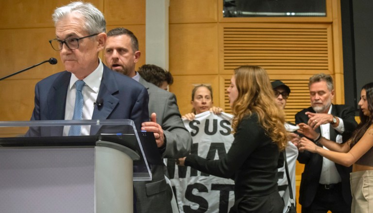 Federal Reserve Chairman Jerome Powell is escorted off stage after climate protesters interrupted his speech Thursday, Nov. 9, 2023, in Washington.
