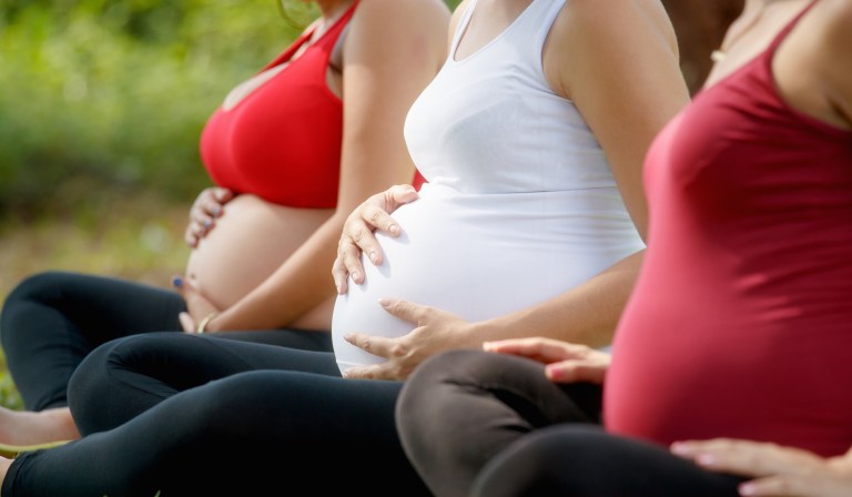 Pregnant women, group of moms during pregnancy attending prenatal lesson in city park. 