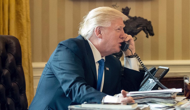 President Donald Trump, accompanied by Chief of Staff Reince Priebus speaks on the phone with Russian President Vladimir Putin, Saturday, Jan. 28, 2017, in the Oval Office at the White House in Washington.